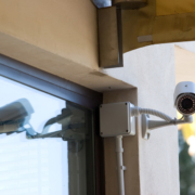 Photo of a bullet surveillance camera mounted outside the front door of a business.