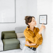 Woman,Controlling,Home,With,A,Digital,Touch,Screen,Panel,Installed