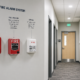 Fire alarm inspector testing a commercial fire alarm system and completing an inspection checklist